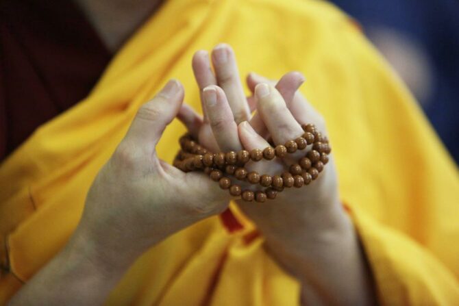 AP Photo buddhist woman praying hands beads